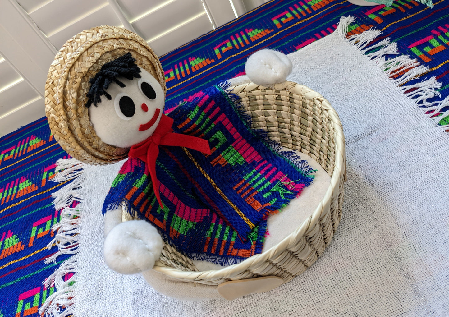Modeled after our Lalo character, this large tortilla warmer will grab the attention of your guests. With its large capacity palm basket, it can hold at least 30 corn tortillas or at least 20 regular size flour tortillas. Perfect for serving rolls, bread, crackers, or fruit too. Lalo is wearing a colorful poncho made with a traditional Cambaya fabric.