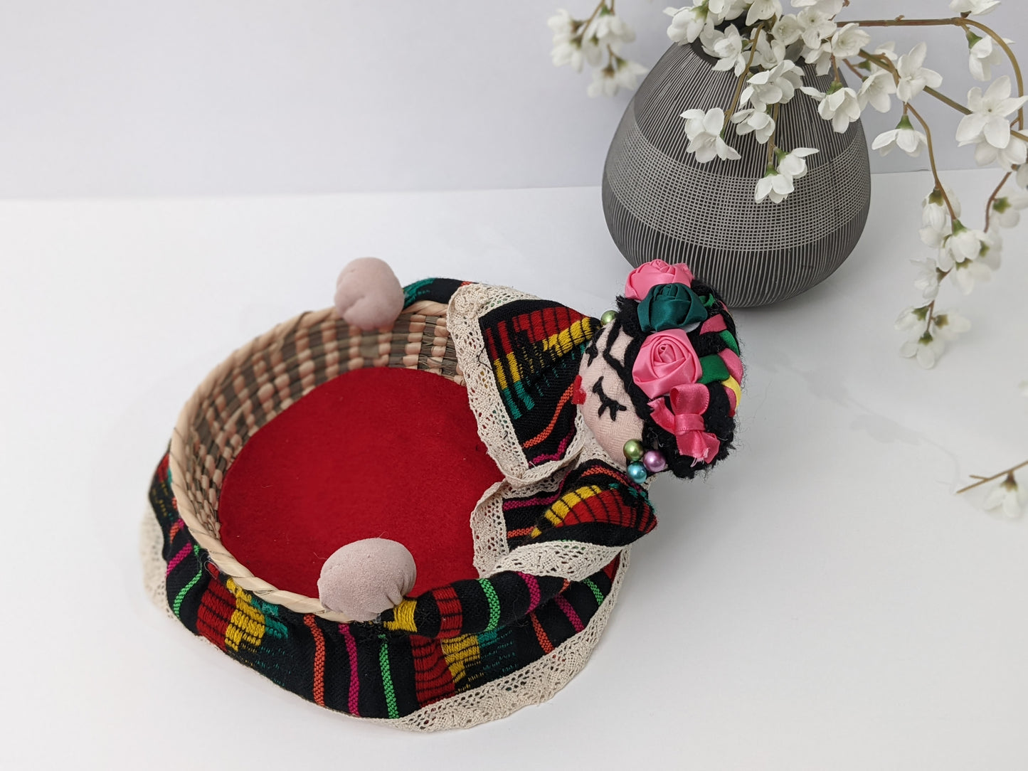 Small Decorative Basket Frida Kahlo by Luna Marie Designs. Our version of Frida Kahlo- Small Palm Basket dressed in black cambaya, tipic Kahlo's hair style adorned with multiple ribbon colors and multicolor roses. Frida 0003 Side a